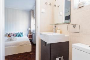 uma casa de banho com um lavatório e um quarto com uma cama em Nesha Lucky nr. 23 em Lisboa