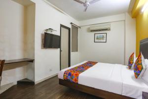 a bedroom with a bed and a flat screen tv at FabHotel All In One in New Delhi