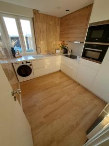 a kitchen with white cabinets and a wooden floor at Casa dos Paralelos in Moledo +10 photos
