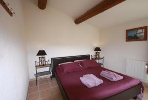 a bedroom with a bed with two towels on it at Hameau des Oraisonis in Bras-dʼAsse