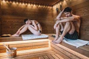 a man and woman sitting in a sauna at Elite Hotel & Spa in Mestre