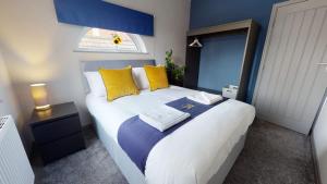 een slaapkamer met een groot bed met gele en blauwe kussens bij South Drive Bungalow in Middlesbrough