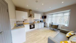 a kitchen and living room with a couch and a table at South Drive Bungalow in Middlesbrough