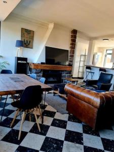 a living room with a couch and a table and a piano at Appartement 2 chambres in Aire-sur-la-Lys