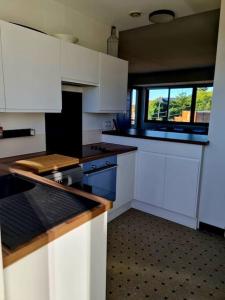 a small kitchen with white cabinets and a window at Appartement 2 chambres in Aire-sur-la-Lys +3 photos