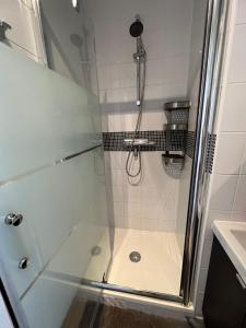 a bathroom with a shower with a glass door at Studio moderne au cœur de Paris Batignolles in Paris