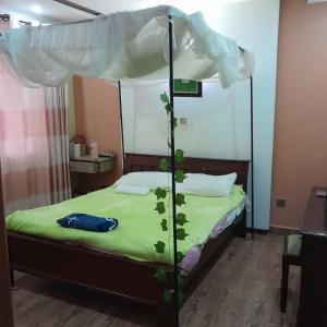 um quarto com uma cama de dossel e um lençol verde em Pazuri homes em Kalimoni