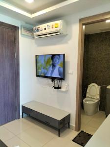 a room with a tv on a wall with a toilet at Arcadia beach continental in Pattaya South