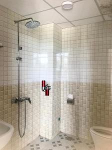 a bathroom with a shower and a toilet at Thăng Long Hotel in Dong Hoi