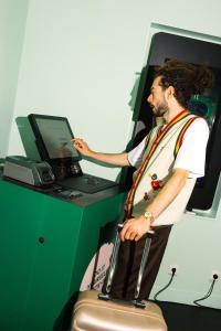 a man standing at a cash register with a suitcase at Qbic Amsterdam WTC in Amsterdam