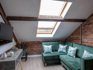uma sala de estar com um sofá verde e uma televisão em Pass the Keys Wonderful historic conversion em Doncaster