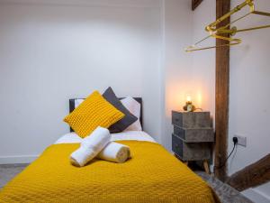 a bedroom with a yellow bed with a yellow blanket at Pass the Keys Wonderful historic conversion in Doncaster