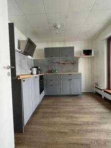 duża kuchnia z szarymi szafkami w pustym pokoju w obiekcie OF01 71m² große Unterkunft für bis zu 5 Personen w mieście Heusenstamm