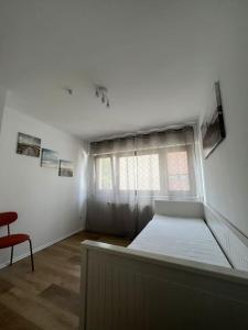 1 dormitorio con cama, ventana y silla en OF01 71m² große Unterkunft für bis zu 5 Personen, en Heusenstamm