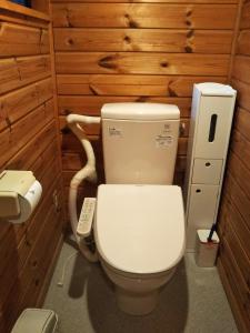 een badkamer met een toilet in een houten muur bij 御師の家　梅谷（UMEYA） in Fujikawaguchiko