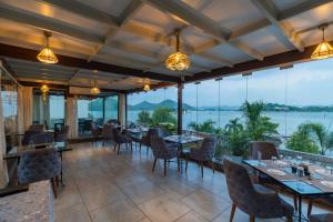 a restaurant with tables and chairs and a view of the water at Panna Vilas - A Lake Facing Boutique Hotel in Udaipur +68 photos