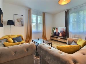 a living room with two couches and a tv at Superbe * maison moderne * proche centre * parking privé in Angers