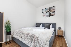 biała sypialnia z dużym łóżkiem i kocem w obiekcie Apartament Słoneczne Pilice w Jastrzębiej Górze