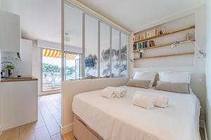 a bedroom with a large white bed with two pillows at L'Embarcadère - Petit paradis 1ère ligne vue mer in Arcachon