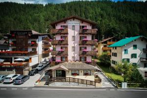 una vista aerea di un hotel con auto parcheggiate in un parcheggio di Hotel Villa Emma a Madonna di Campiglio