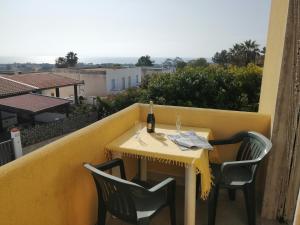 a table with a bottle of wine on a balcony at Casa Fenice in Marinella di Selinunte
