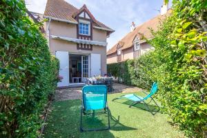 two chairs and a table in the yard of a house at Azul - Maison avec jardin à 200m de la plage in Courseulles-sur-Mer +4 photos