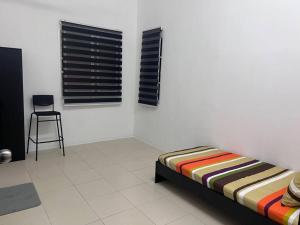 a bedroom with a bed and a chair and a window at D' Tronoh Home in Teronoh