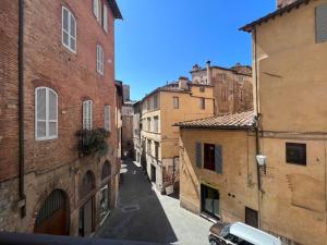 un callejón en una ciudad italiana con edificios en Torre del Cavaliere, en Siena