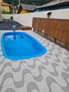 uma piscina azul num piso de azulejo em Casa Copacabana 2 em Urubici