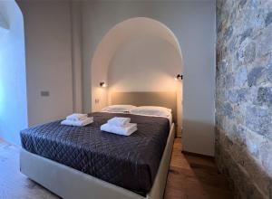 1 dormitorio con 1 cama con 2 toallas en Torre del Cavaliere, en Siena