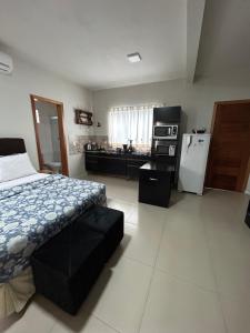 um quarto com uma cama e uma cozinha com um frigorífico em Casa Copacabana 2 em Urubici