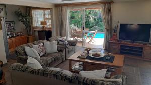 een woonkamer met 2 banken en een televisie bij Bella Vista Guest House in Durban