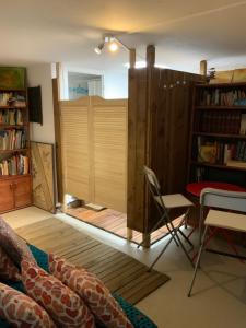 a room with a book shelf and a table and chairs at Villa Akwaba in Pyla-sur-Mer