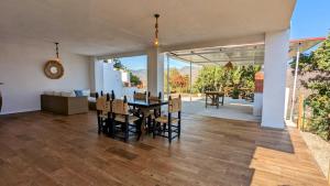 a dining room and living room with a table and chairs at Casa Rural Pagalván in Málaga