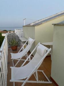 zwei weiße Stühle auf einem Balkon mit Meerblick in der Unterkunft La Casa Bianca in Ceriale