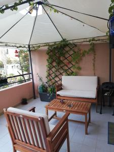 een patio met een bank, een tafel en een tent bij Iknos House in Monserrato