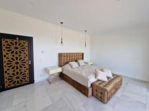 um quarto com uma cama, um sofá e uma mesa em Villa avec vue exceptionnelle em Tânger