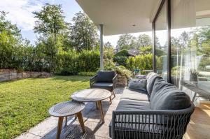 un soggiorno con divano e 2 tavoli di Bauhausvilla am Ammersee a Herrsching am Ammersee