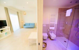 a bathroom with a shower and a toilet and a television at Regiohotel Manfredi in Manfredonia