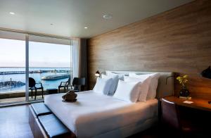 a hotel room with a bed and a large window at Octant Ponta Delgada in Ponta Delgada