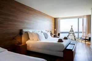 a hotel room with two beds and a large window at Octant Ponta Delgada in Ponta Delgada