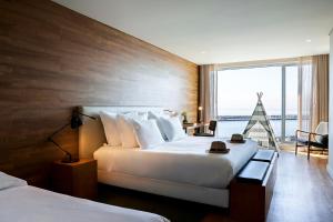 um quarto de hotel com duas camas e uma grande janela em Octant Ponta Delgada em Ponta Delgada
