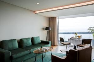 a living room with a green couch and a table at Octant Ponta Delgada in Ponta Delgada