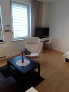 ein Wohnzimmer mit einem Stuhl und einem Tisch in der Unterkunft TOP! möbliertes Apartment mit Parkplatz Nähe Messe Essen in Mülheim an der Ruhr