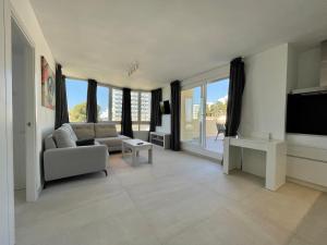 a living room with a couch and a tv at Apartamentos Orfeo Azul in Benalmádena