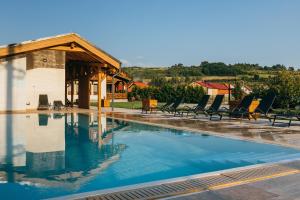a swimming pool with chairs and a house at Hygge Praid in Praid