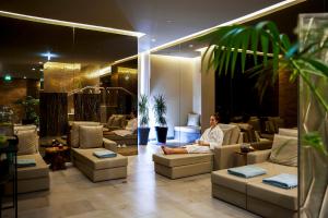 a man sitting on a couch in a lobby at Octant Ponta Delgada in Ponta Delgada