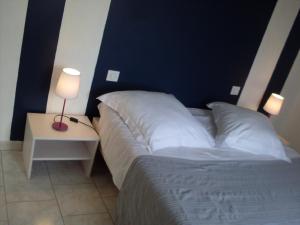 1 dormitorio con 1 cama y 1 mesa con lámpara en Gîte de Fourneaux en Pont-d'Ouilly