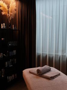 Una toalla en una cama en una habitación con ventana en Amberton Green SPA Druskininkai en Druskininkai