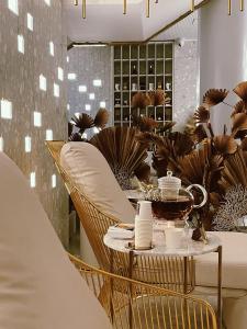 une table et des chaises dans un restaurant avec des plantes dans l'établissement Amberton Green SPA Druskininkai, à Druskininkai